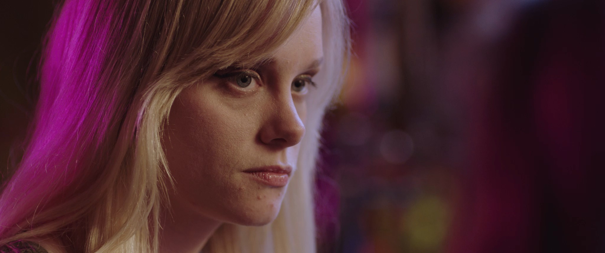This image is a still from Sonja Kelly's proof-of-concept short film Surrender Heaven which was shot in 2017 by director of photography Peggy Peralta. It features a young blonde woman in a bar looking at another person.